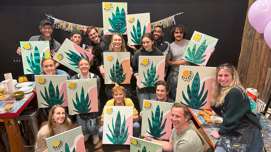 Female friends posing with paintings