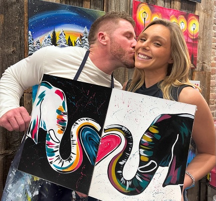 980-3 Man kissing woman on cheek holding paintings