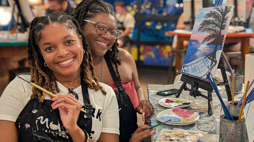 980-banner-image Female friends posing with paintings